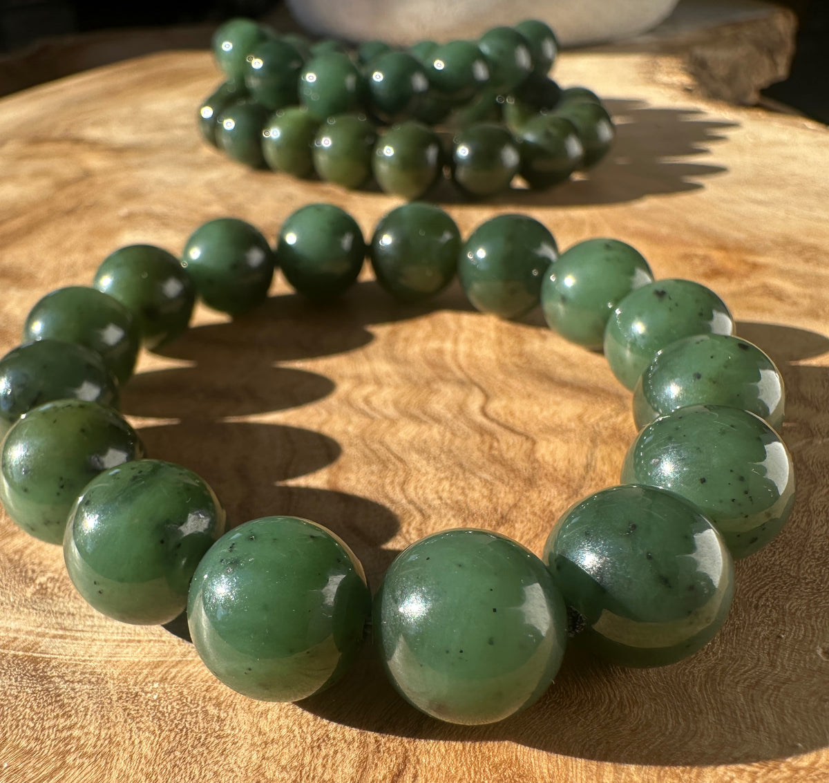 12mm River Canadian nephrite jade bead bracelet on wood surface