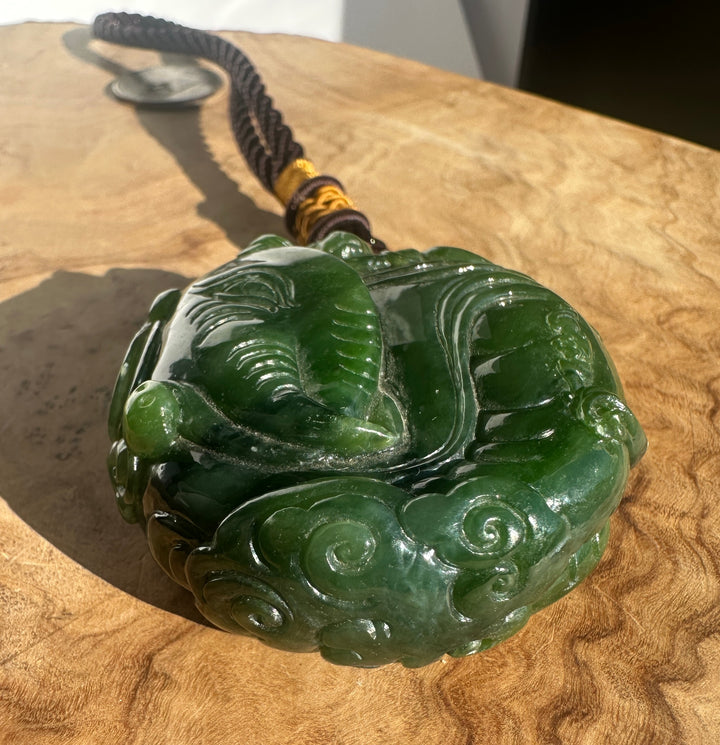 Close up of the black braided cord with yellow wrap above the pendant, highlighting the string work.