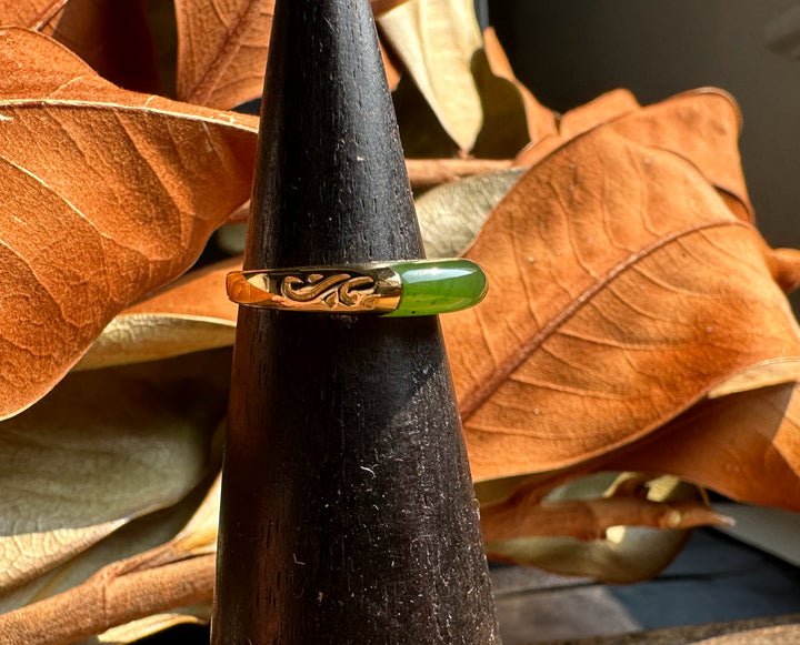 Ring R0392 green enamel inlay set in a gold-tone band with a carved swirl, displayed on a black display cone.