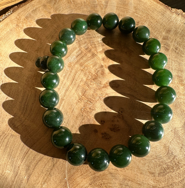 Dark green bead bracelet on a wooden base