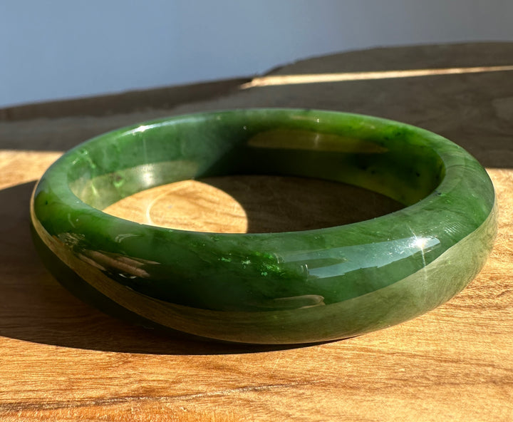 Close up of the jade bangle edge with vivid green color and polished finish.