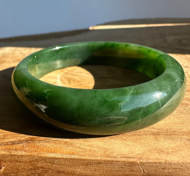 Canadian Jade Bangle viewed from above against a blue backdrop.