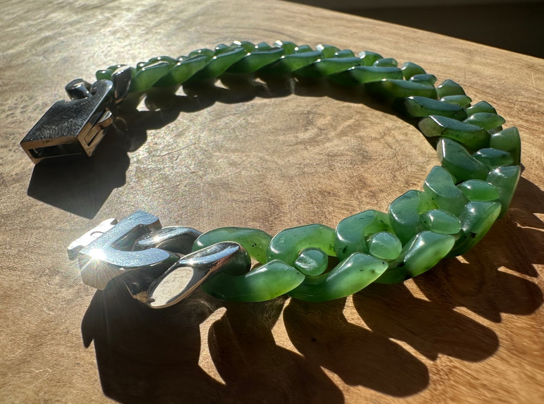 A Grade Canadian nephrite Cuban link bracelet worn on the wrist with a polished silver clasp in sunlight
