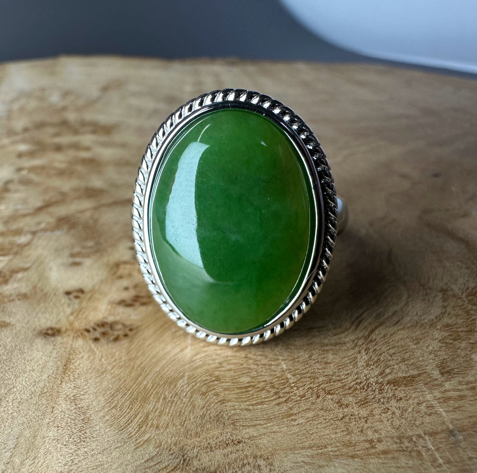 Oval green jade ring with a twisted rope silver bezel.