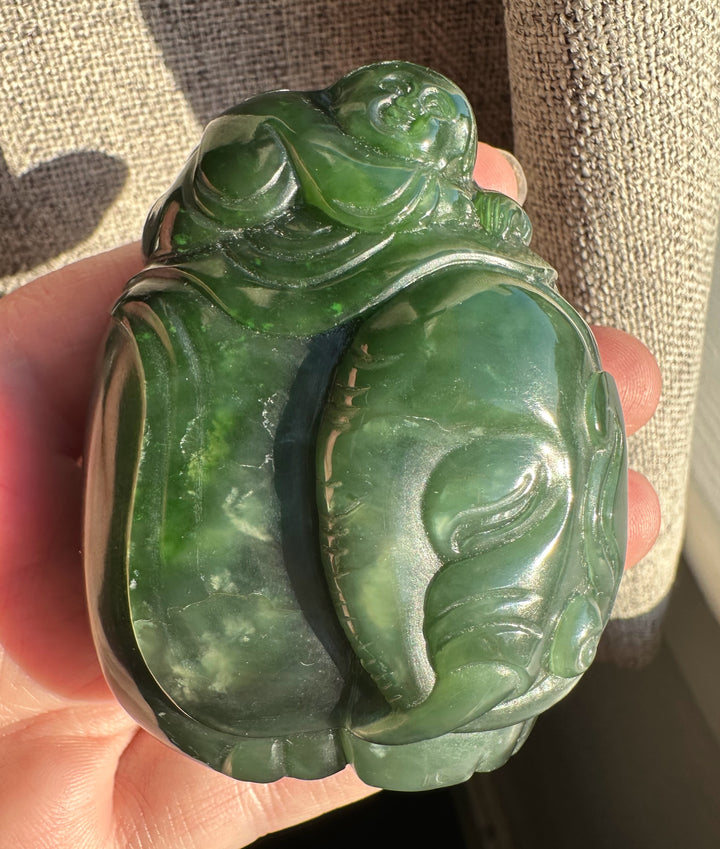 Close-up of jade carving showing a small rider atop the elephant on green jade