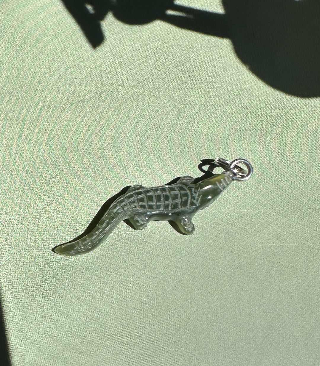Dark green jade alligator pendant with metal loop at its head