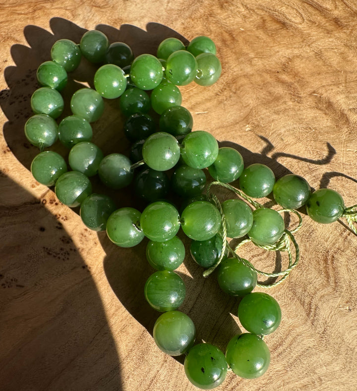 8mm green Canadian beads on a looped cord forming a loose strand