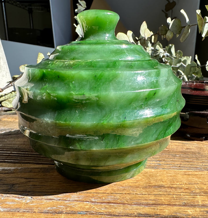 Polar Jade Pot with lid in bright green marble on a weathered wooden surface