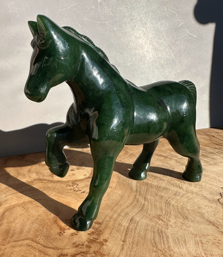 Profile view of the glossy dark green Canadian nephrite jade horse figurine five inches.