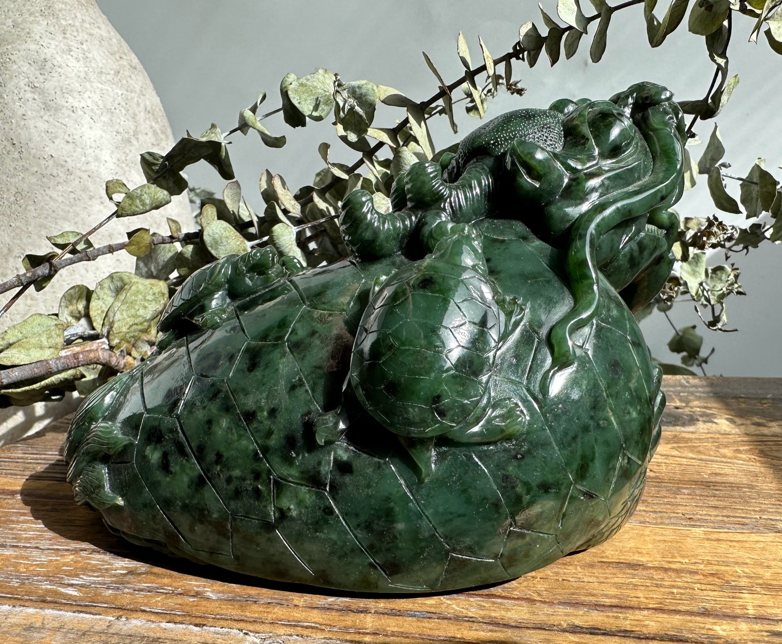 Dark green jade dragon turtle sculpture with dragon perched along the shell and detailed scales