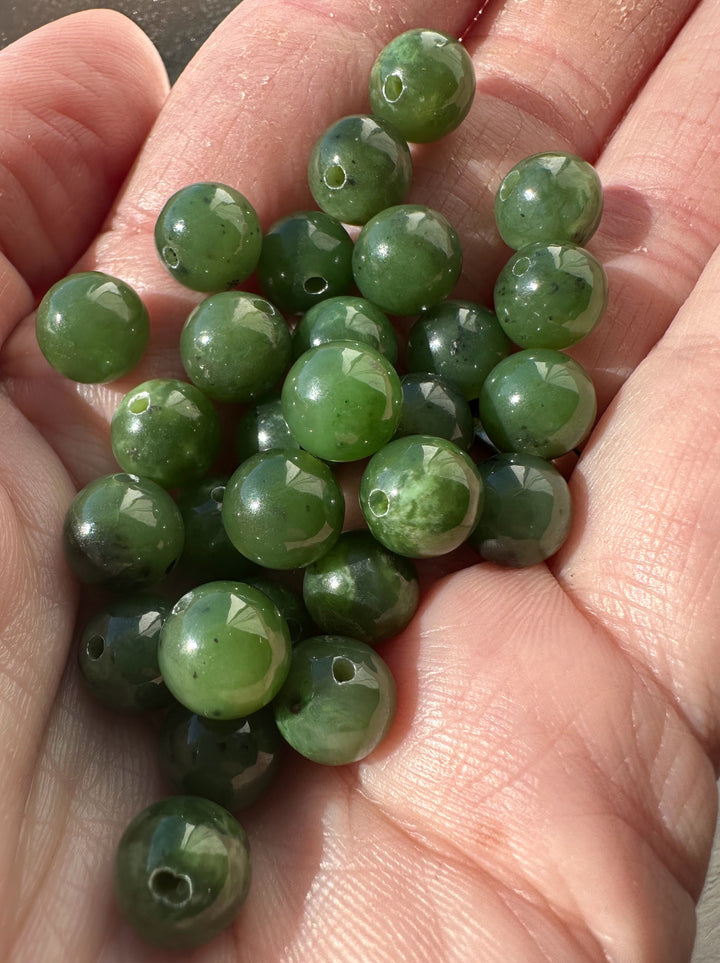Handful of 8mm Canadian jade beads with drilled holes for jewelry