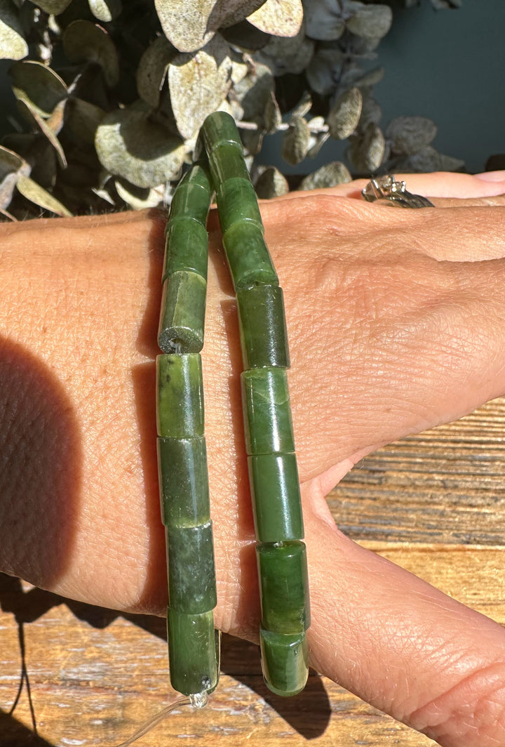 Close up of green Siberian Jade tube beads wrapped around the wrist.