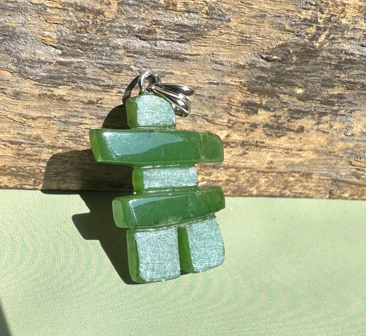 Inukshuk pendant crafted from stacked green jade pieces with a silver bail.