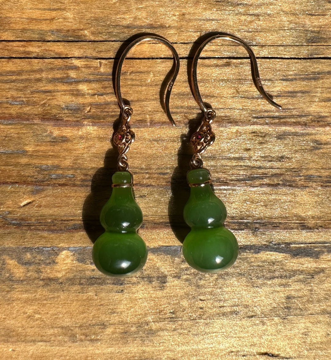 Green jade gourd drop earrings with ornate metal caps on curved hooks