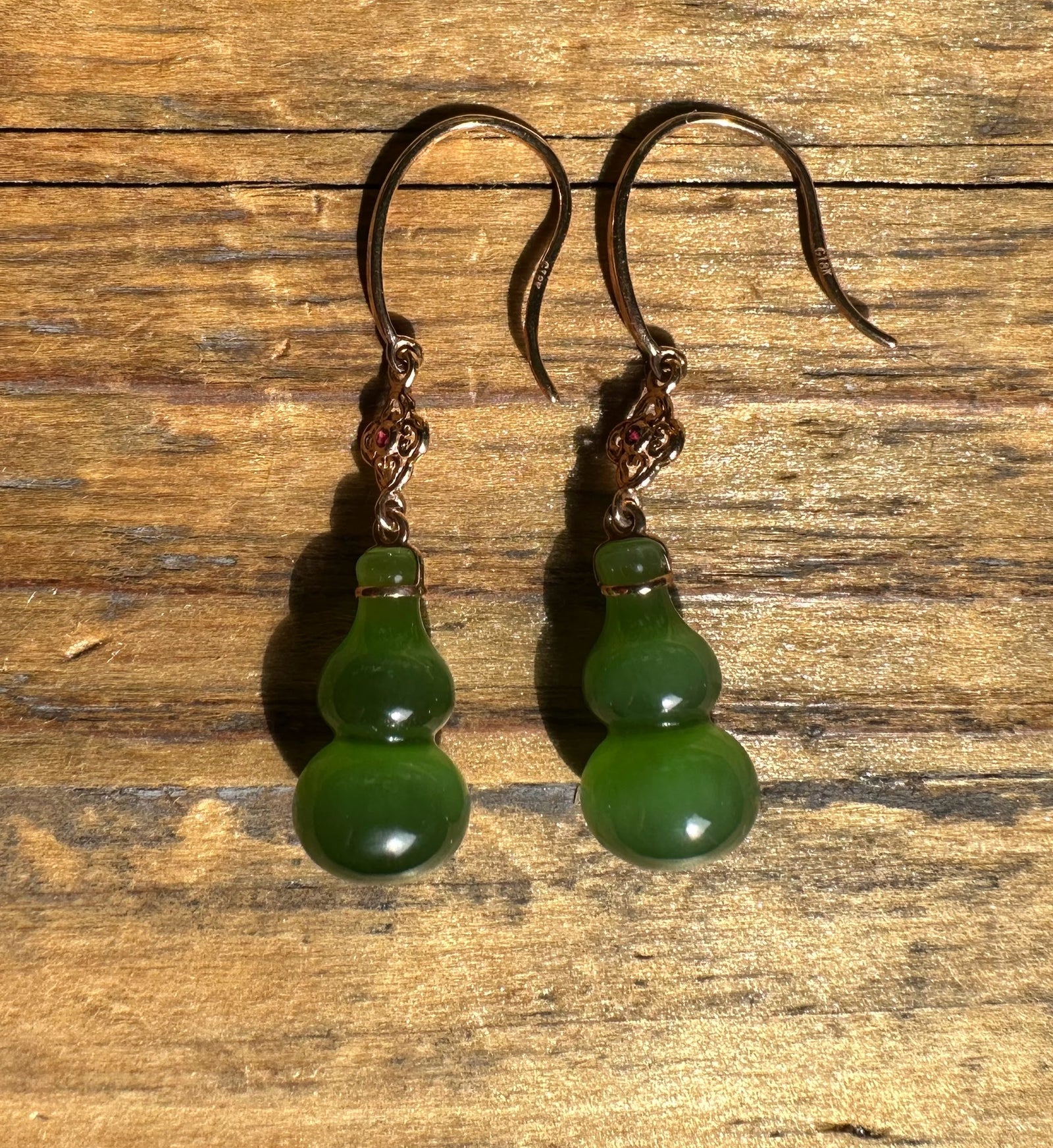 Green jade gourd drop earrings with ornate metal caps on curved hooks