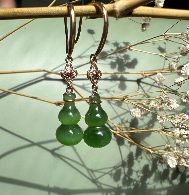 Dangling earrings with rose gold hooks, ornate filigree top with a pink gemstone and green jade gourd pendants.