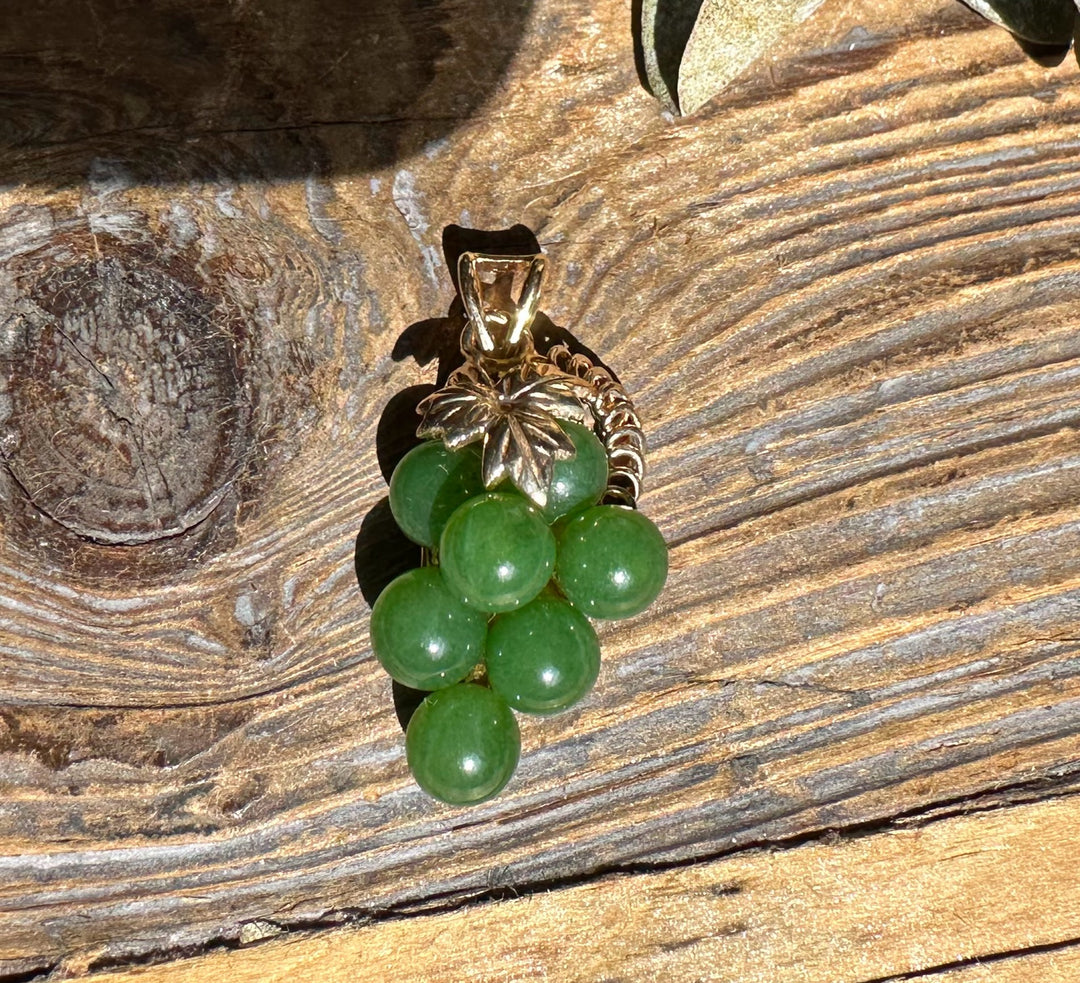 Vintage jade grape pendant with a cluster of green jade beads beneath a leaf cap.