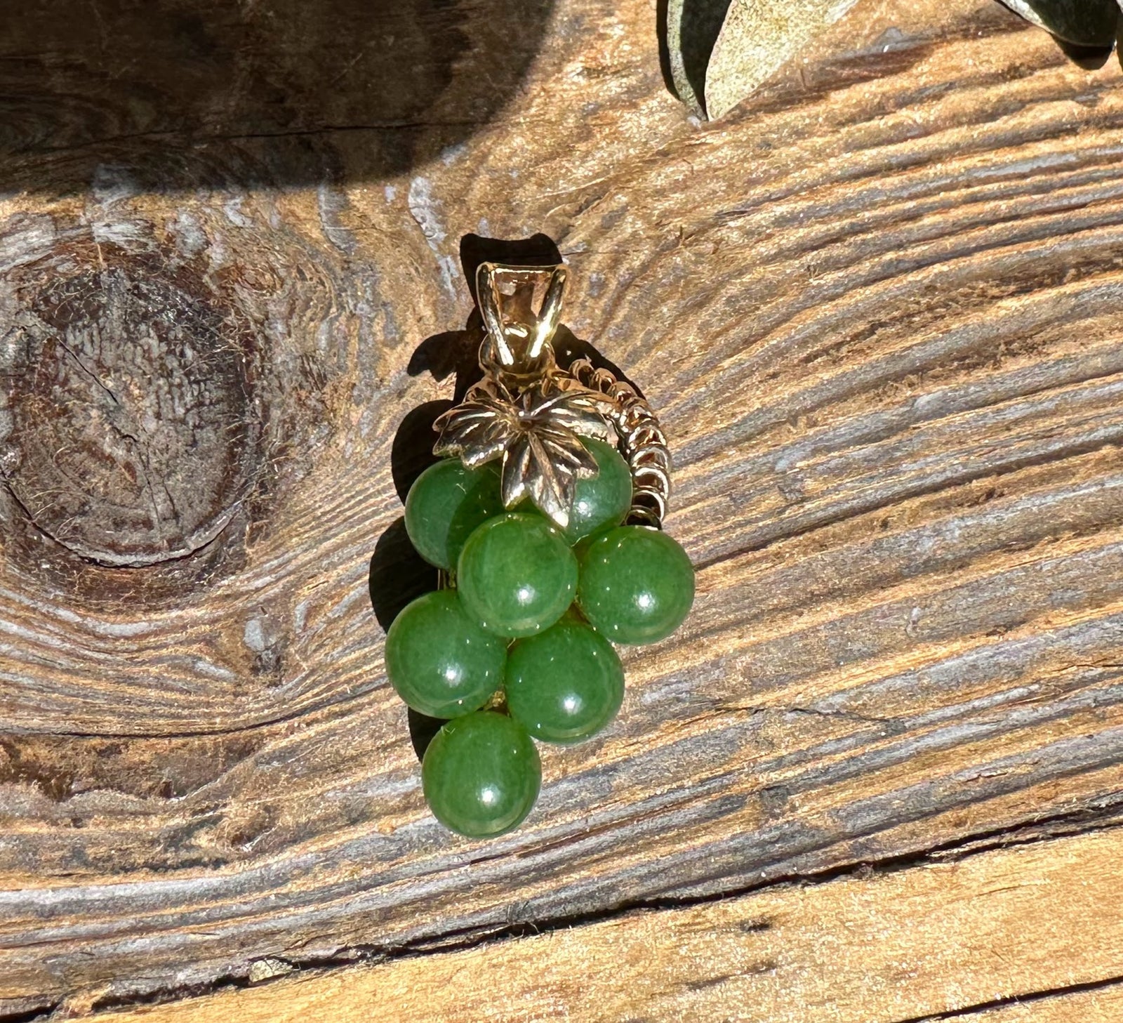 Vintage jade grape pendant with a cluster of green jade beads beneath a leaf cap.