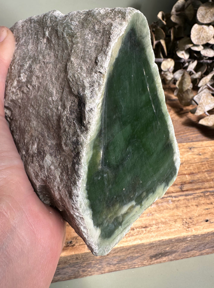 Rough Siberian nephrite with gray crust and dark green interior exposed.