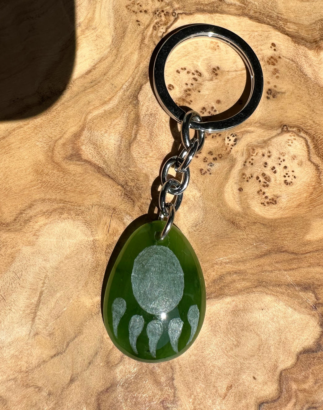 Green teardrop keychain pendant with silver bear paw print motif and metal chain