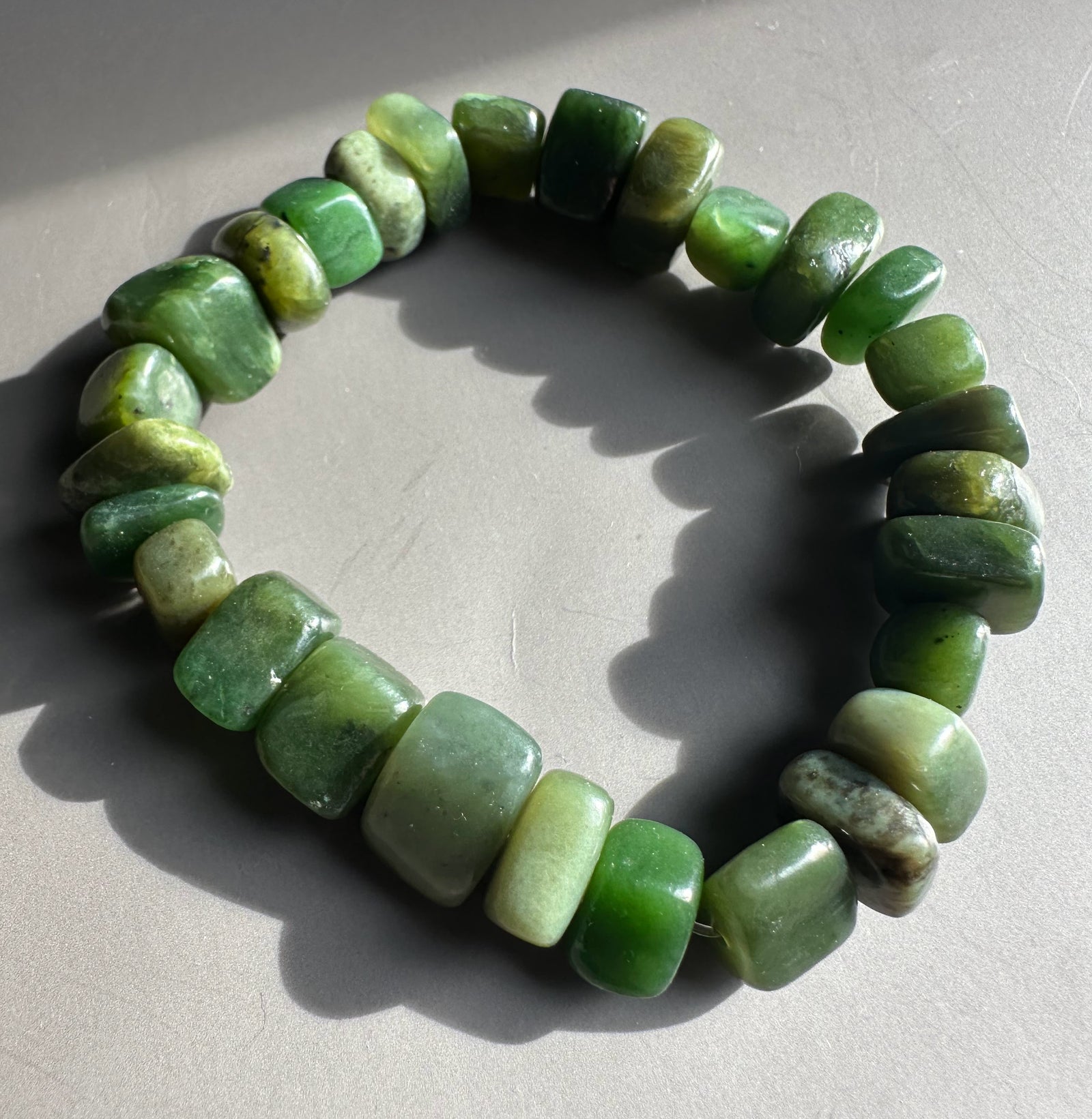 Close up of satin finish green nugget bracelet showing irregular square beads in varying greens