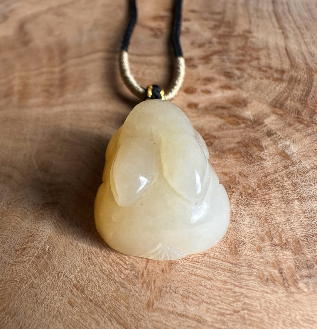 Honey nephrite jade bunny pendant on a black and gold cord