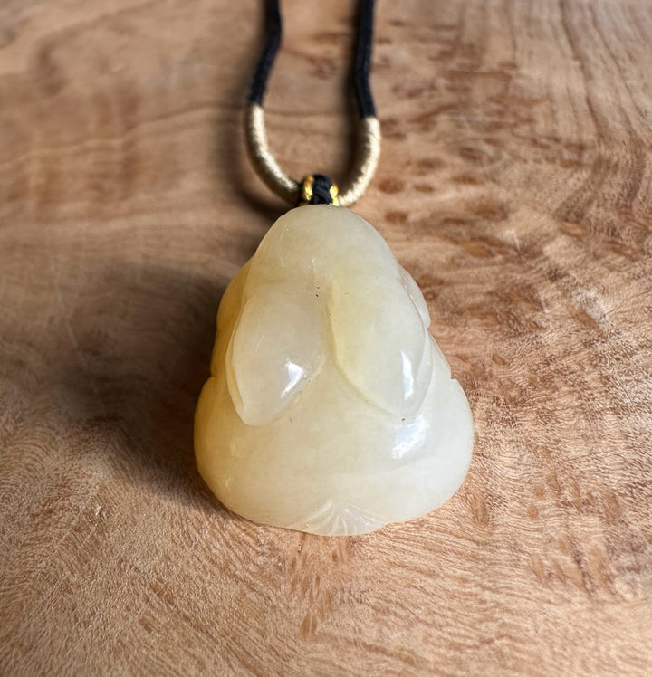 Honey nephrite jade bunny pendant on a black and gold cord