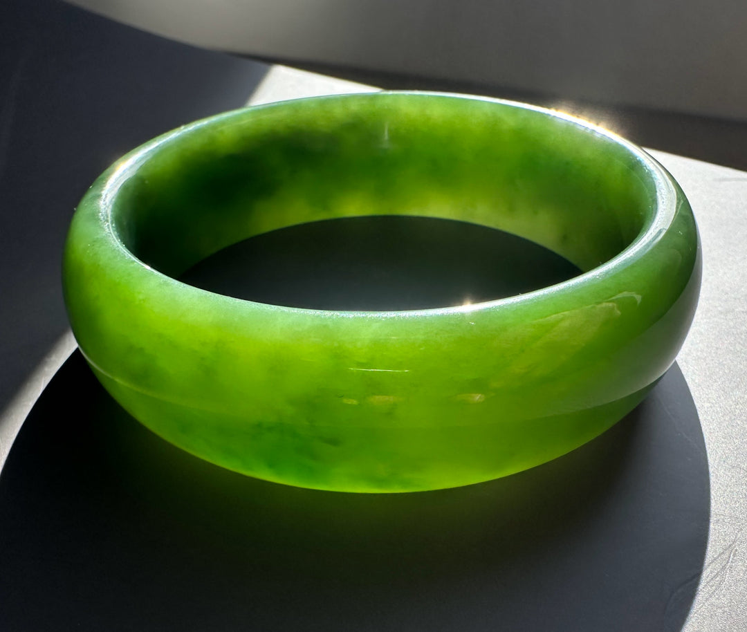 AA Grade Siberian Bangle 60 x 19mm in vivid green jade, close-up side view highlighting thickness and glossy finish.
