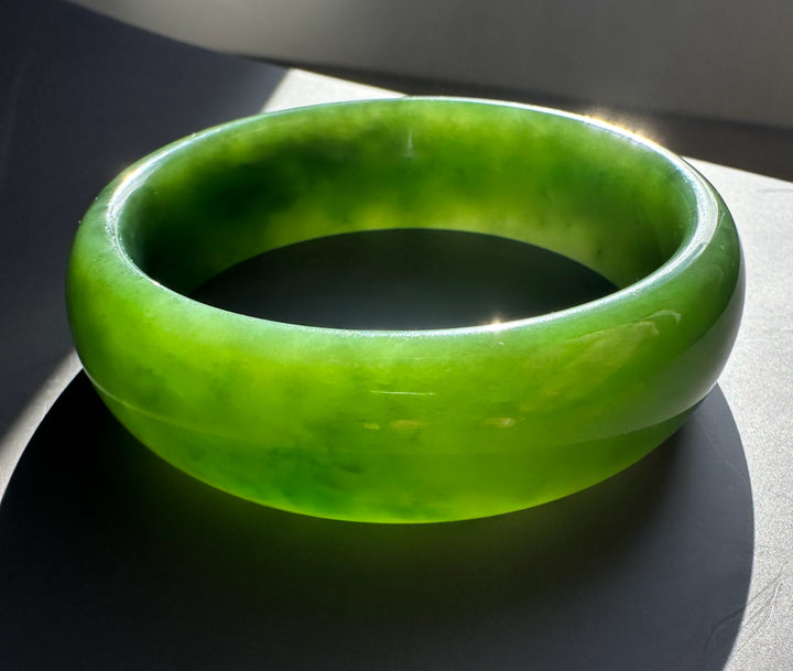 AA Grade Siberian Bangle 60 x 19mm in vivid green jade, close-up side view highlighting thickness and glossy finish.