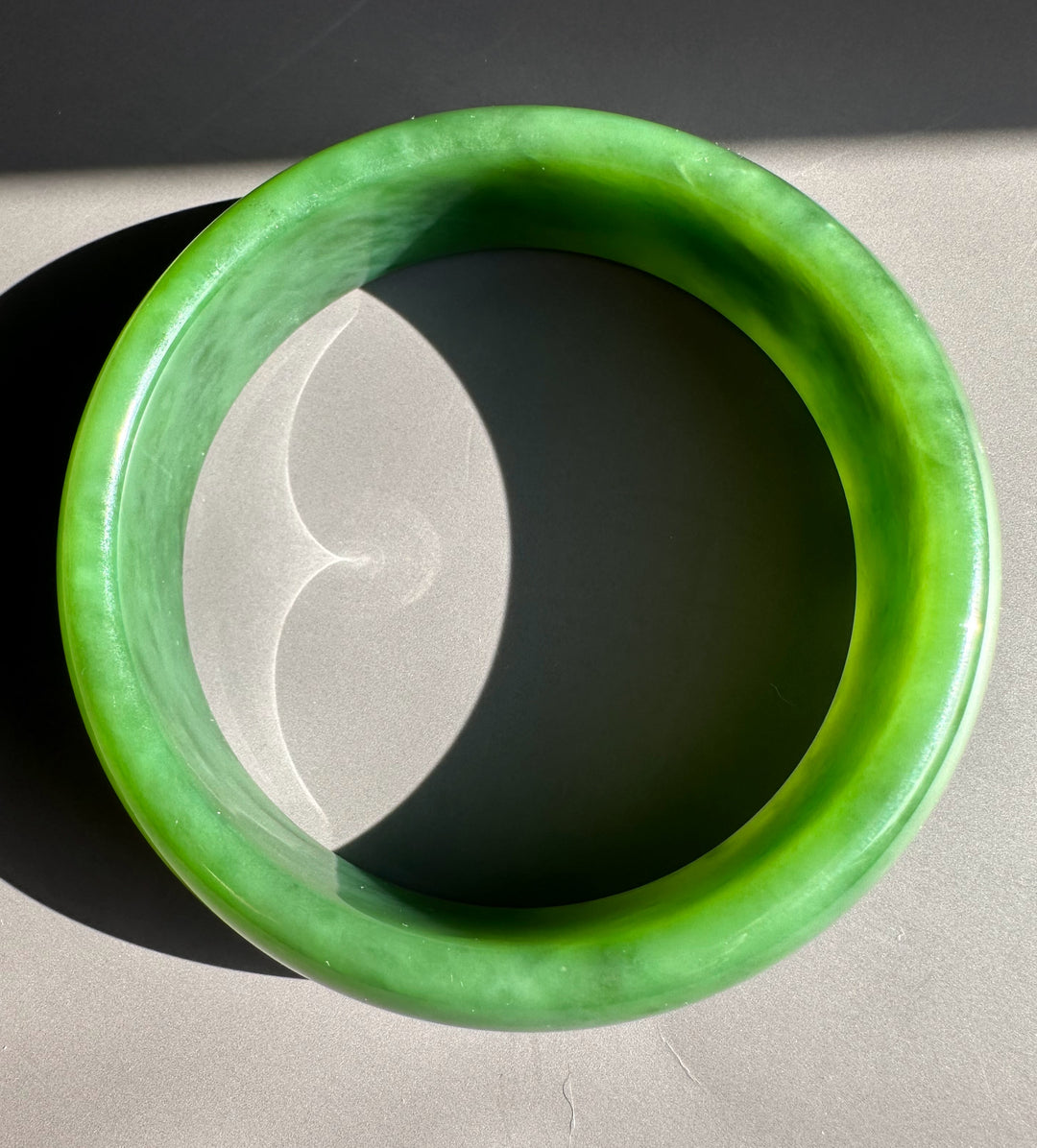 AA Grade Siberian Bangle 60 x 19mm in vivid green jade, top view showing smooth glossy exterior.