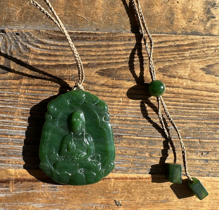 Green jade Guanyin pendant on a beige braided cord with jade beads