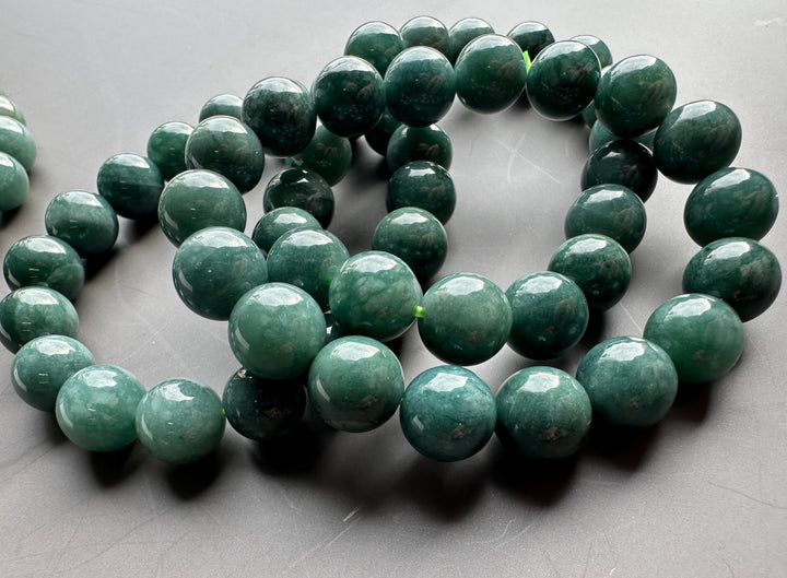 Guatemalan jadeite bead bracelet with 10mm glossy green beads coiled in a close up shot