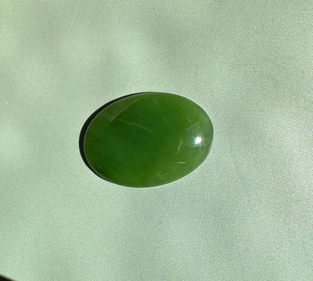Oval Canadian nephrite jade cabochon 18x25mm with a glossy green finish.