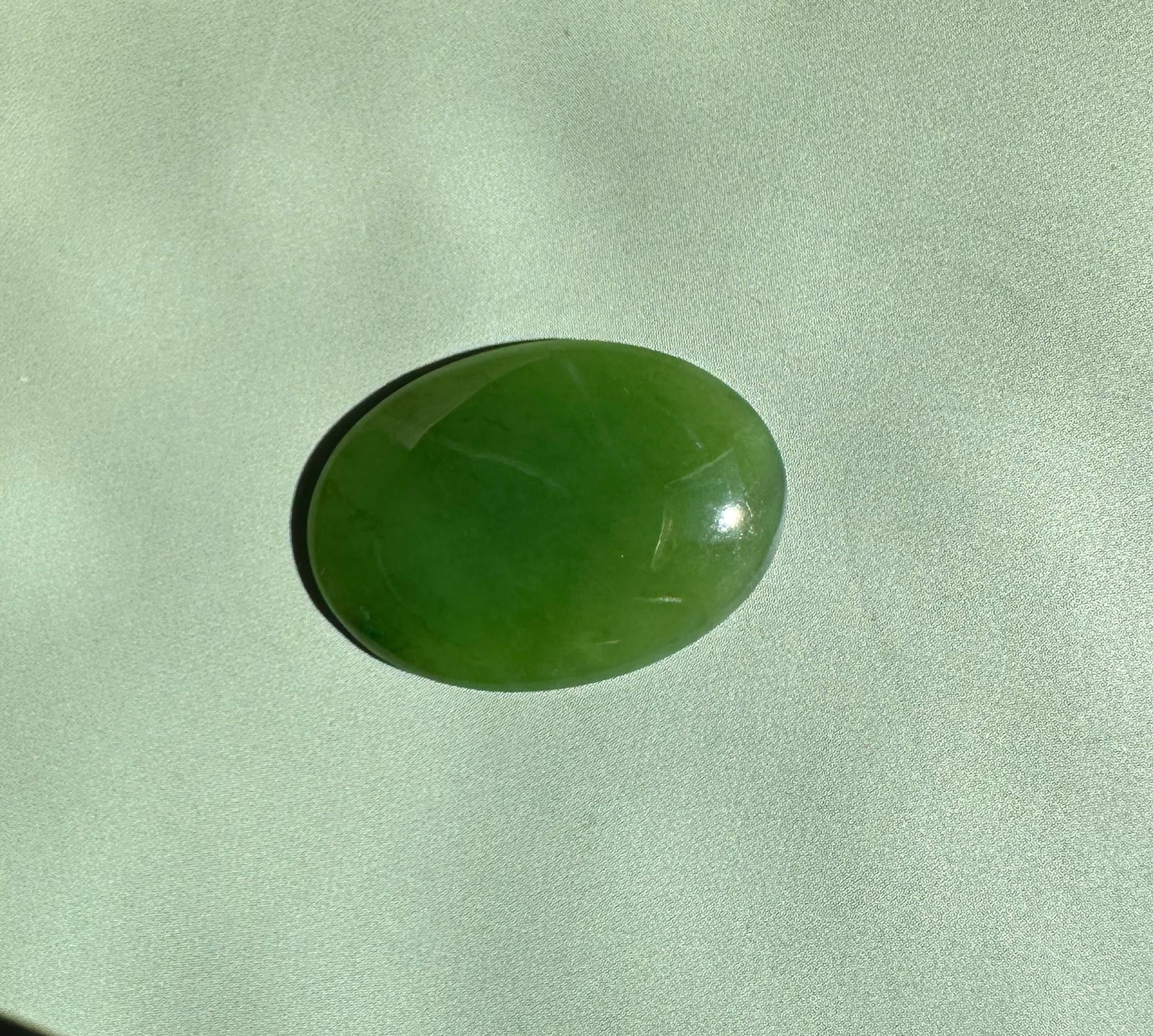 Oval Canadian nephrite jade cabochon 18x25mm with a glossy green finish.
