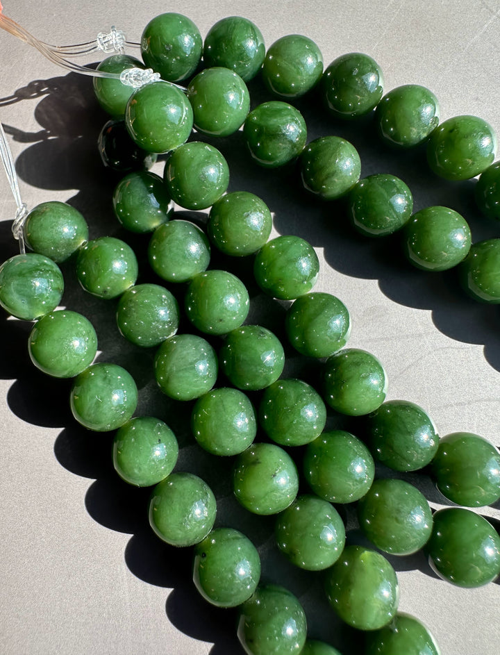 8mm dark green Canadian unstrung beads arranged on a gray surface