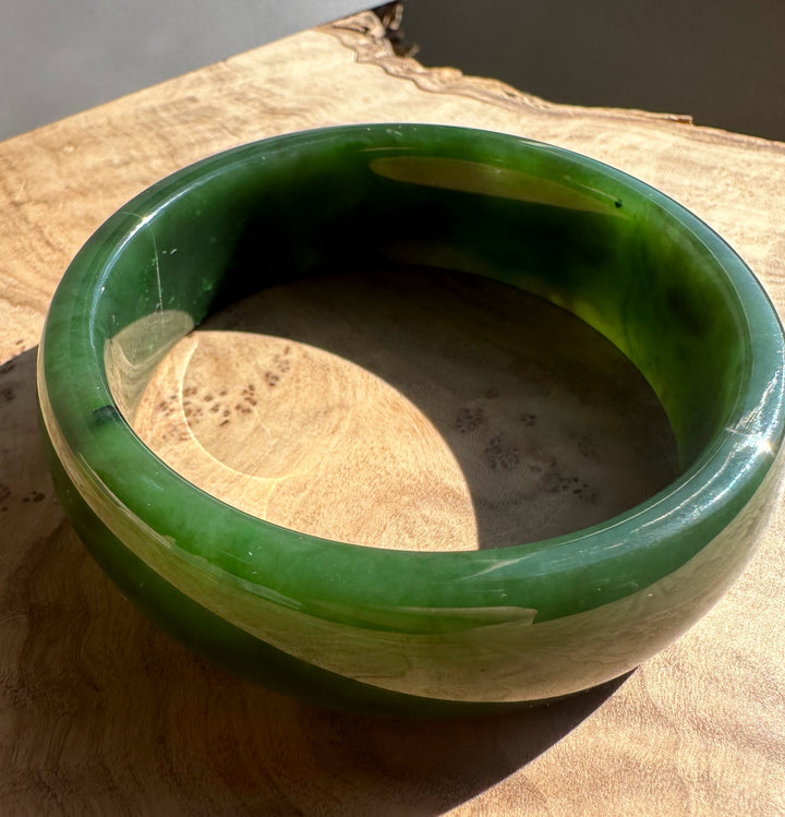 Interior view of the jade bangle highlighting the thick translucent green material and smooth inner edge.