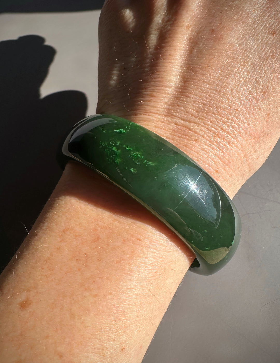Canadian Jade Bangle on the wrist with a glossy dark green finish
