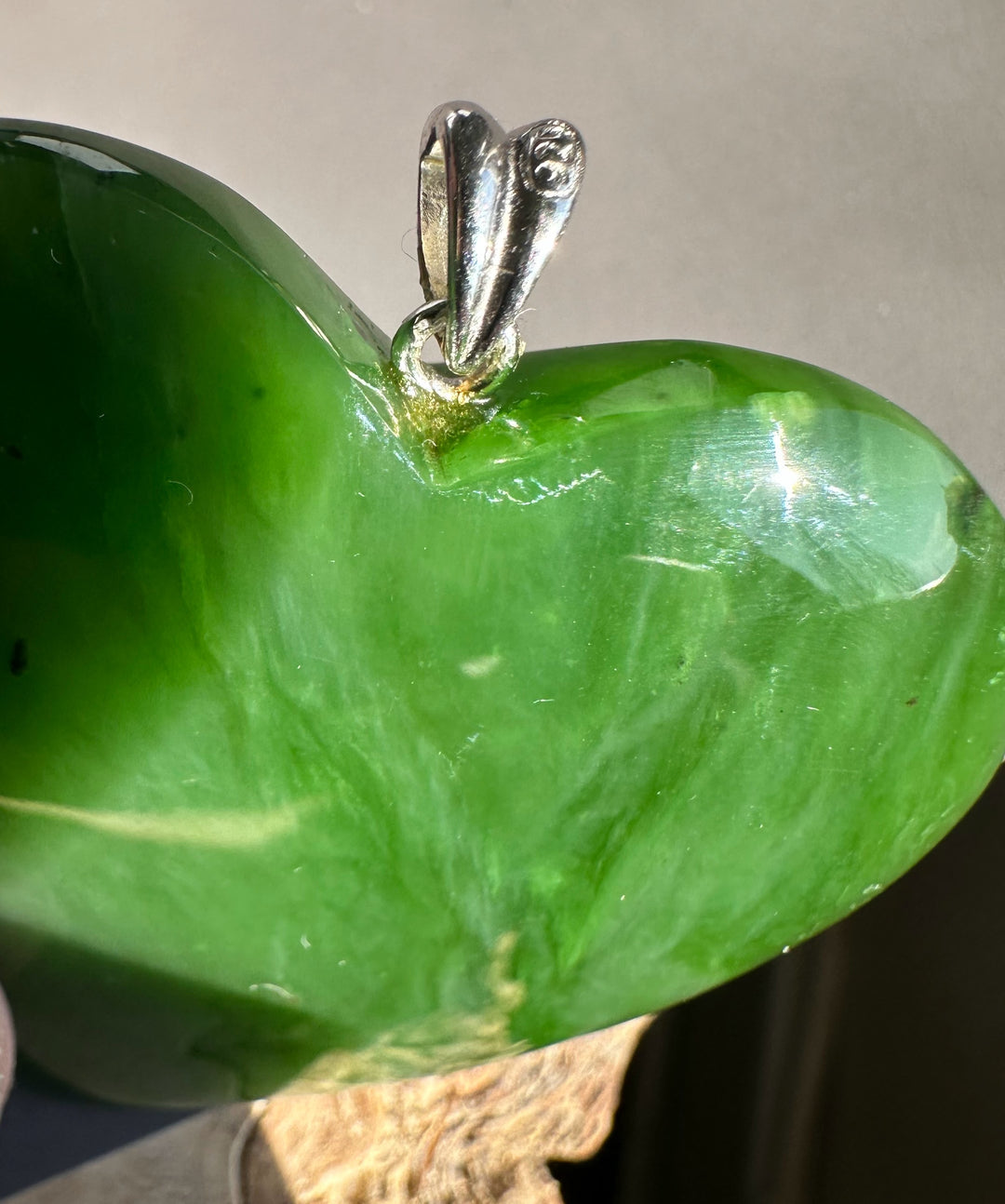 Close-up of the silver bail on a green Polar Jade heart pendant.