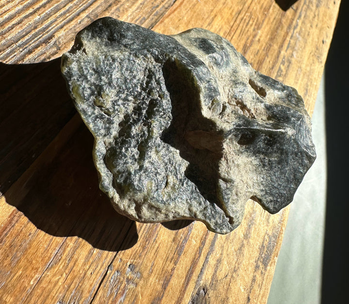 Close-up of Wyoming Olive Jade Slick with rough gray beige surface and natural crevices