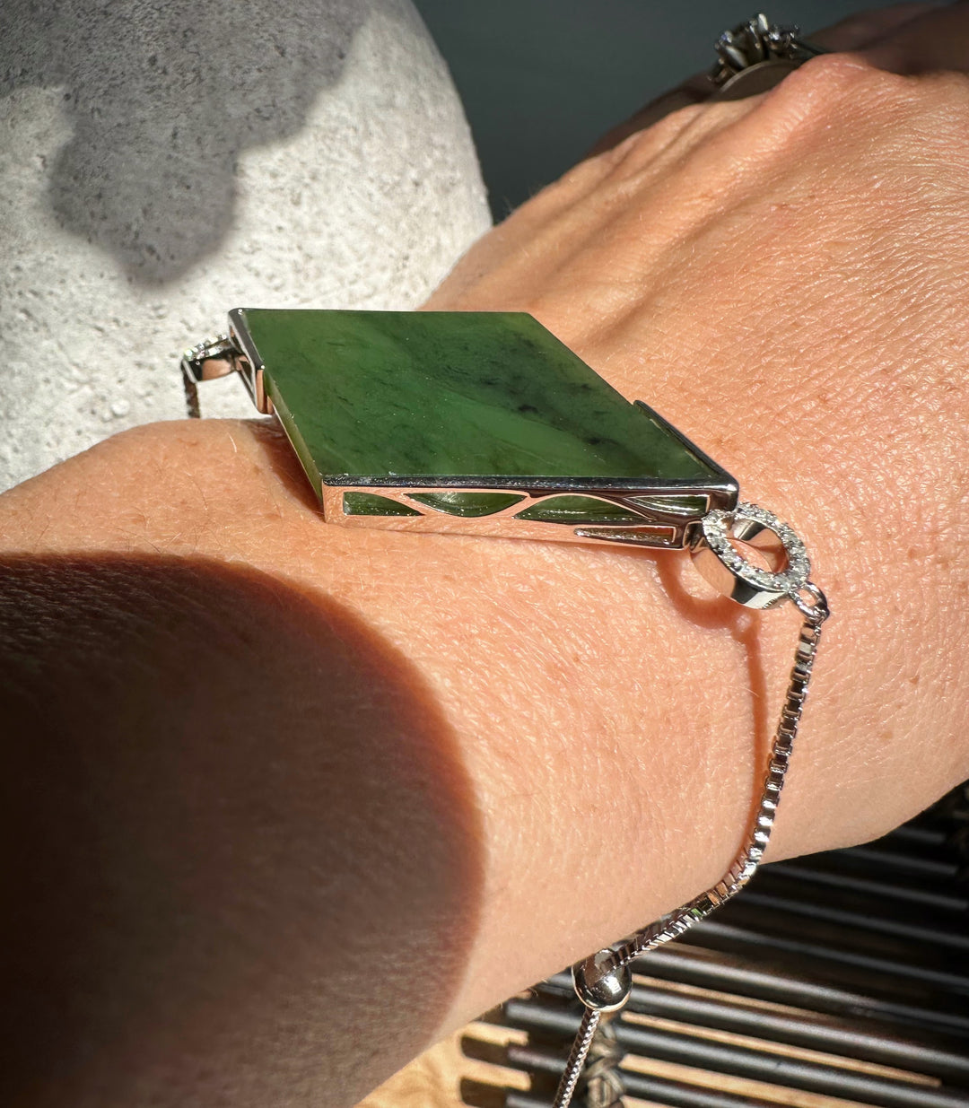 Sterling silver bracelet with a large rectangular green Canadian jade centerpiece on the wrist.