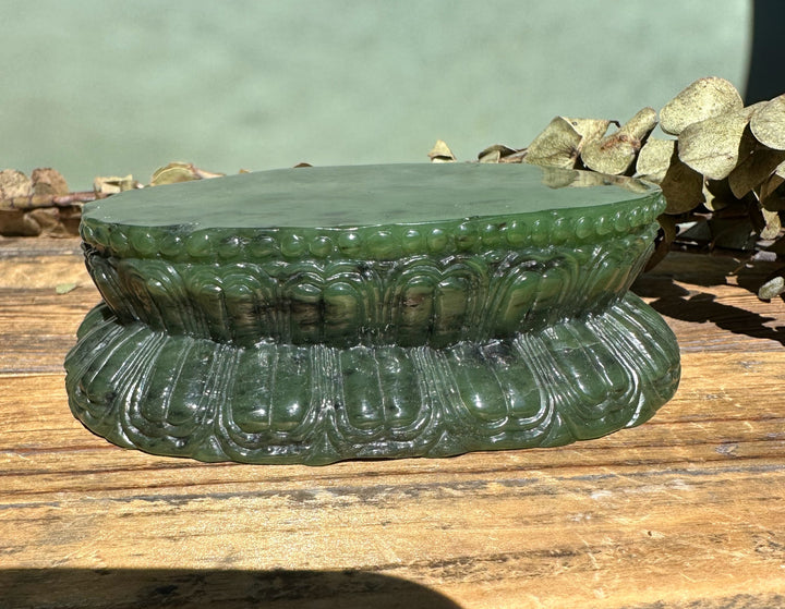 Side view of the 7.5 inch Shakyamuni Buddha carved from nephrite jade on a fluted round base.