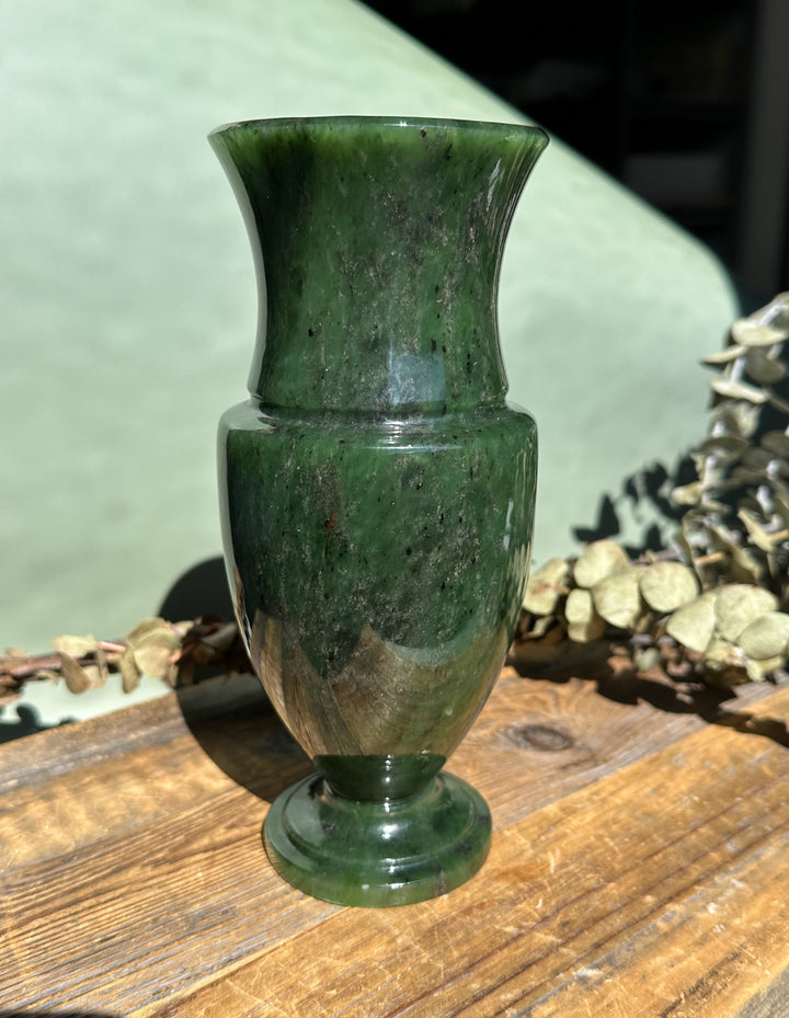 Siberian Jade Vase with rounded body and pedestal base showing variegated green and brown tones on a wooden surface.
