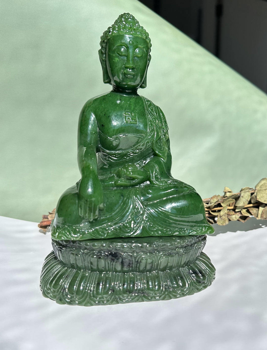 Emerald green nephrite Shakyamuni Buddha carved statue seated in lotus on a decorative base