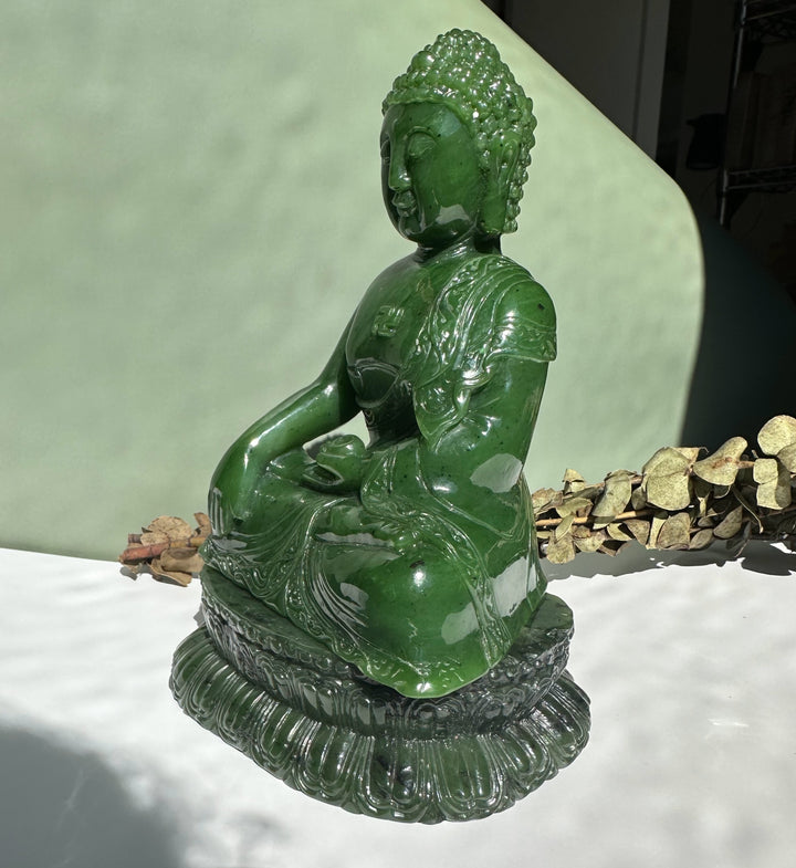 Shakyamuni Buddha 7.5 inch carved from green Canadian nephrite jade, seated in meditation on a tiered pedestal