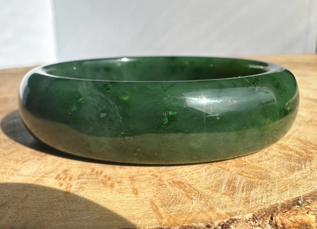 Canadian Jade Bangle 56 x 17mm, glossy green jade bracelet angled to show its rounded form