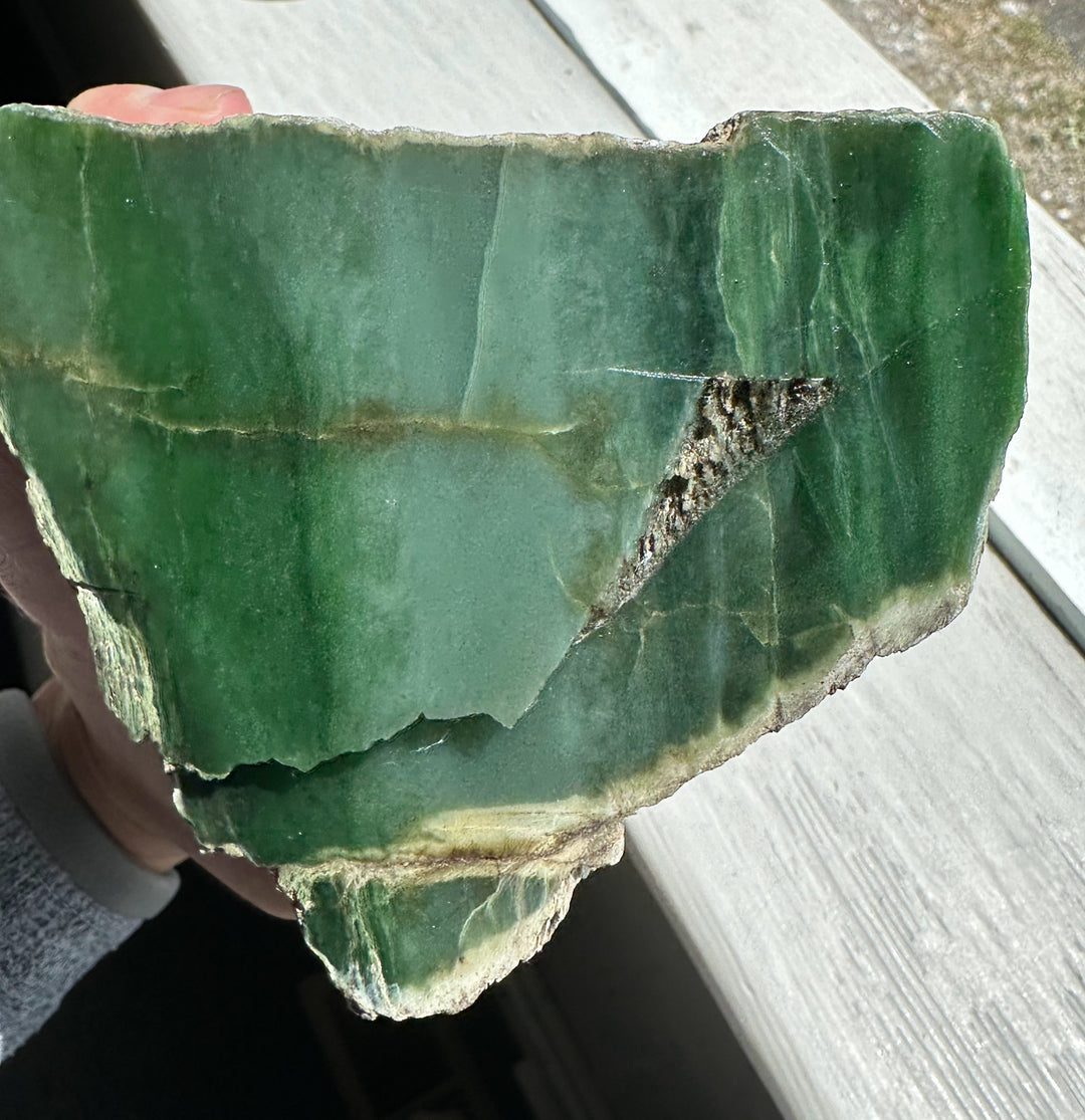 Rough Siberian nephrite jade block in deep green with natural fractures and a jagged edge