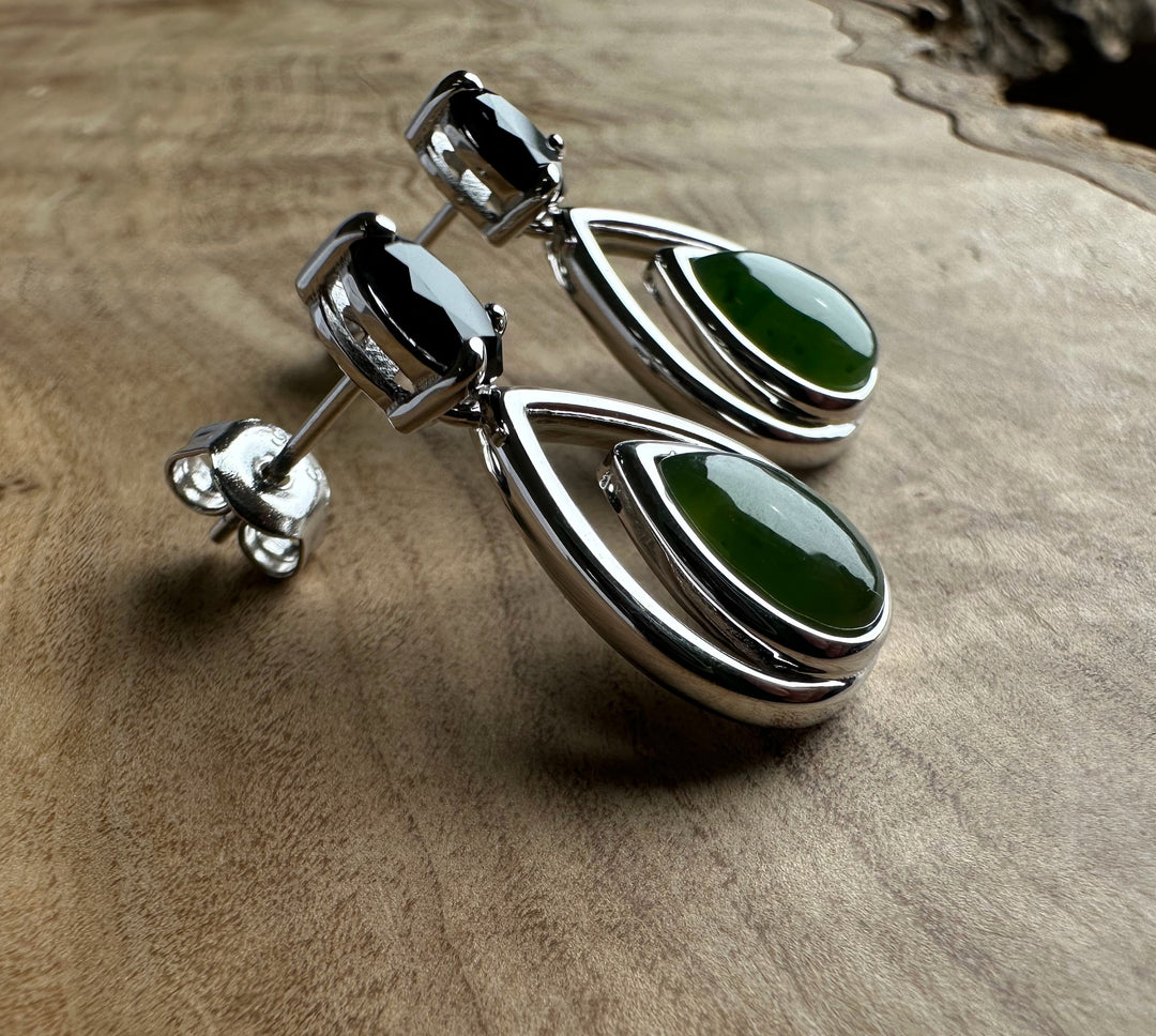Pair of silver earrings with black top stones and green nephrite jade teardrops nested in double curved frames