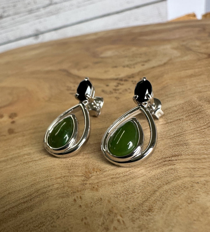 Silver teardrop earrings featuring green nephrite jade drops and a small black gemstone at the top