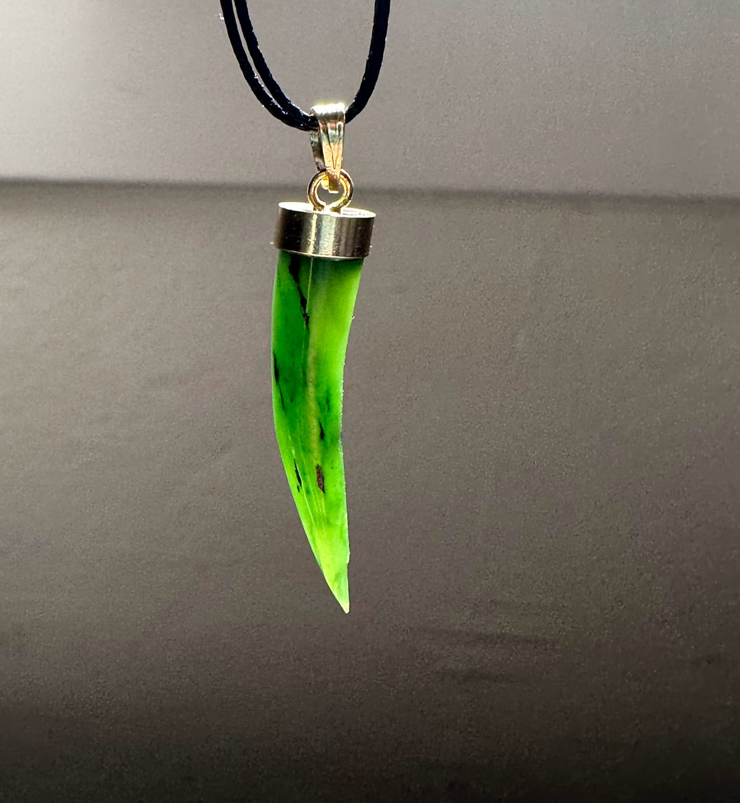 Close up of neon green jade talon pendant on black cord with silver cap