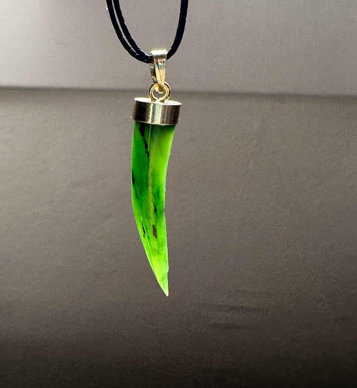Close up of neon green jade talon pendant on black cord with silver cap
